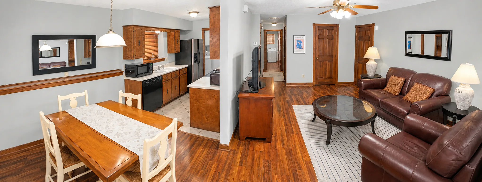 Panoramic view of the living room, dining room, and kitchen in apartment 1301 B